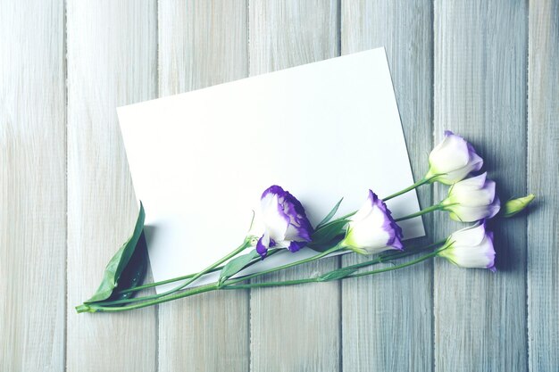 Zdjęcie kompozycja białego prześcieradła i kwiatu na szarym drewnianym tle pustej przestrzeni