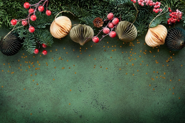 Zdjęcie kompozycja bożonarodzeniowa gałęzie sosnowe z stożkami sosnowymi i papierami wiejskie kulki na starym zielonym betonie wiejskie tło świąteczna kartka powitalna płaski widok z góry banner kopiowania przestrzeni