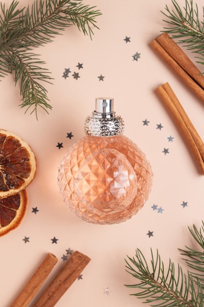 Zdjęcie kompozycja bożonarodzeniowa z perfumami i prezentem na beżowym tle koncepcja bożego narodzenia