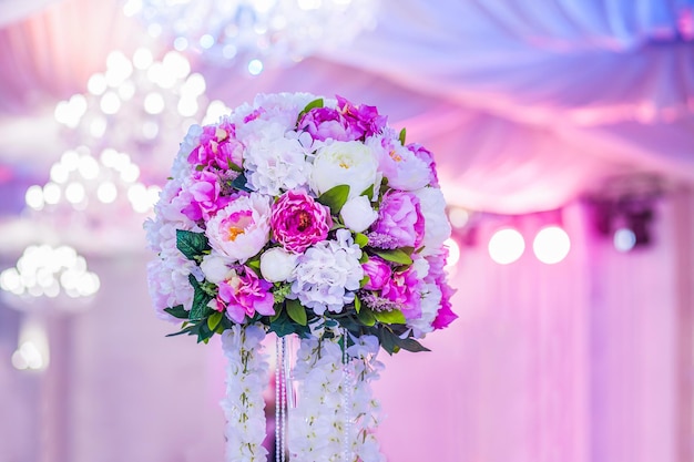 Kompozycja kwiatowa na bankiecie weselnym w restauracji w neonowych kolorach