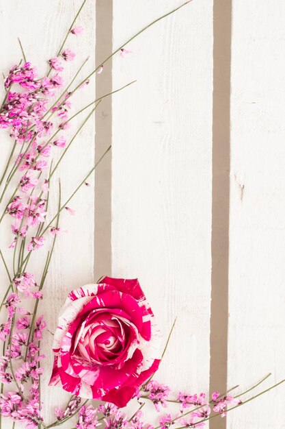 Zdjęcie kompozycja kwiatowa z kwiatem róży na białym drewnie