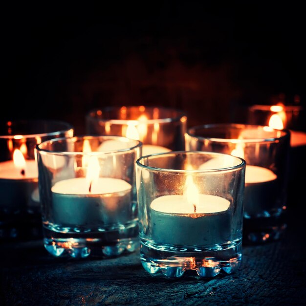 Kompozycja świąteczna lub noworoczna z płonącymi świecami w małym szklanym świeczniku vintage drewniane tło świąteczny wieczór selektywne skupienie