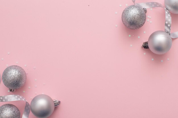 Kompozycja świąteczna, srebrne zabawki z choinki świątecznej i dekoracje świąteczne na różowym tle