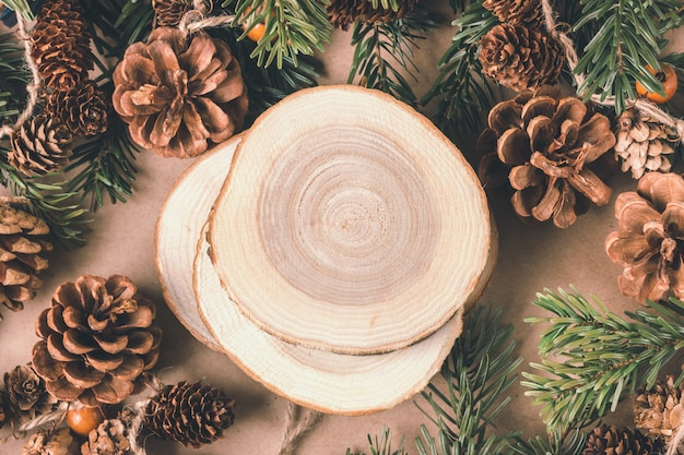 Kompozycja świąteczna. Świerkowe gałęzie, szyszki, drewniane stojaki. Naturalne materiały, ekologiczne dekoracje na nowy rok. Miejsce na tekst