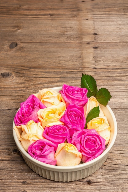 Kompozycja świeżych róż w misce ceramicznej. Świąteczna koncepcja na Wesela, Urodziny, 8 marca, Dzień Matki lub Walentynki. Kartkę z życzeniami, płasko leżący, vintage drewniany stół