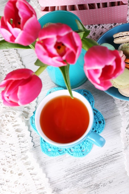 Kompozycja wiosennych kwiatów herbaty i ciastek na zbliżenie stołu