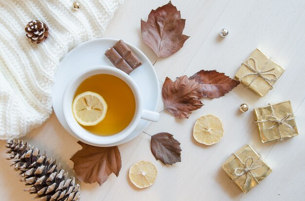 Kompozycja z herbatą, liśćmi, szyszkami, cytryną i swetrem z dzianiny.