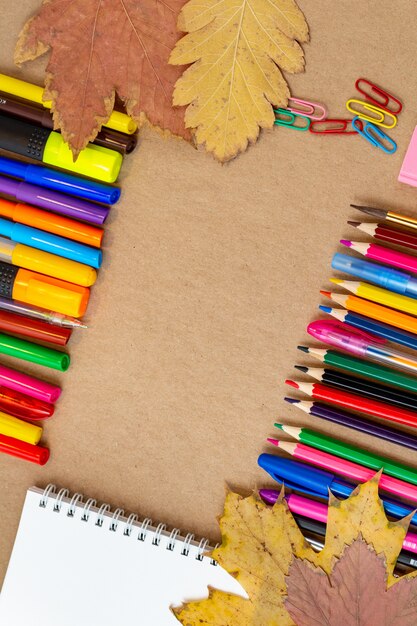 Zdjęcie kompozycja z kolorowych ołówków, flamastrów i długopisów zeszytu