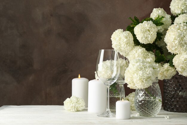 Kompozycja z kwiatów hortensji i świec na brązowej przestrzeni. Romantyczny wieczór