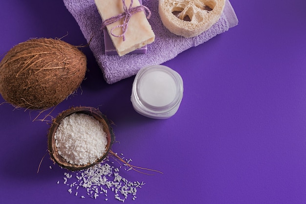 Kompozycja z naturalnym organicznym kremem kosmetycznym do ciała z olejem kokosowym na fioletowym tle