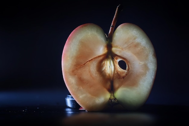 Zdjęcie kompozycja z plastrami jabłka na czarnym tle plasterek jabłka z podświetleniem na czarnym tle z kroplami wody soczyste jabłko na stole