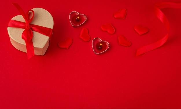 Kompozycja z widokiem z góry na świętego walentynki z sercami świec w pudełku na czerwonym tle