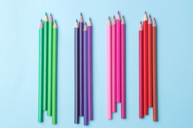 Kompozycja z wielobarwnymi ołówkami z ołówkami na jasnym niebieskim tle. zbliżenie.