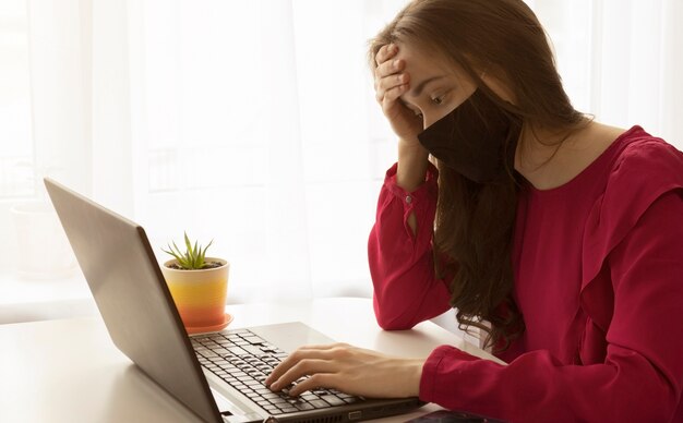 Komputer, laptop i dziewczyna studiująca zdalnie. Pandemia koronawirusa na świecie.