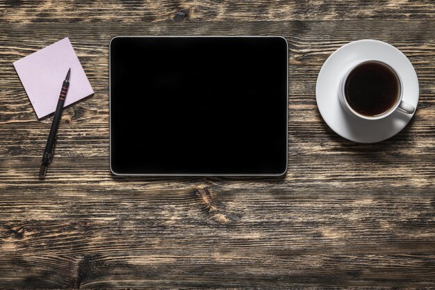 Komputer typu Tablet z kawą na drewnianym stole