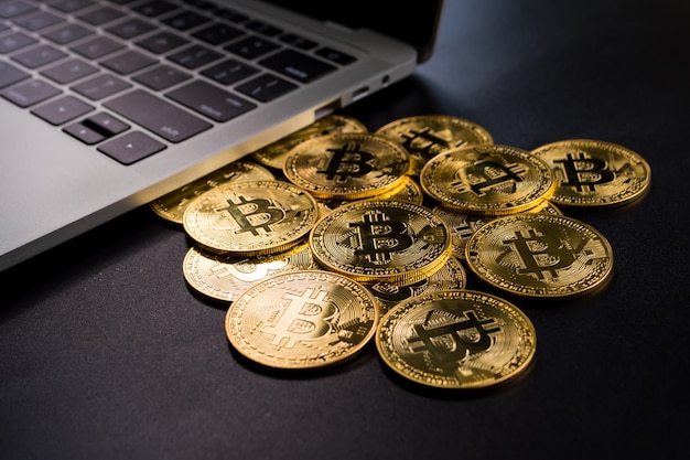 Komputerowe I Złote Monety Z Bitcoin Symbolem Na Czarnym Tle.