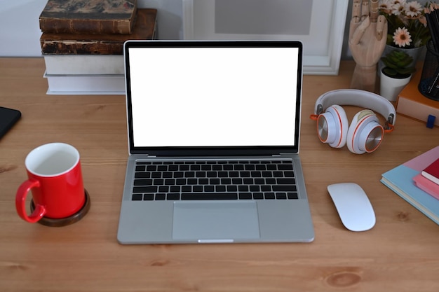 Komputerowy laptop z pustymi słuchawkami i filiżanką kawy na drewnianym biurku