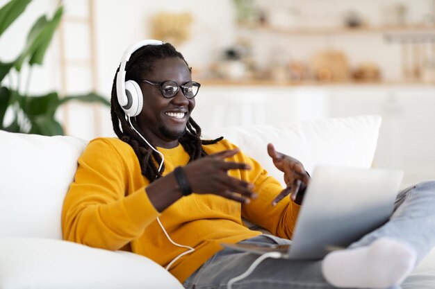 Komunikacja Online Szczęśliwy Murzyn W Słuchawkach Nawiązywanie Połączenia Wideo Na Laptopie