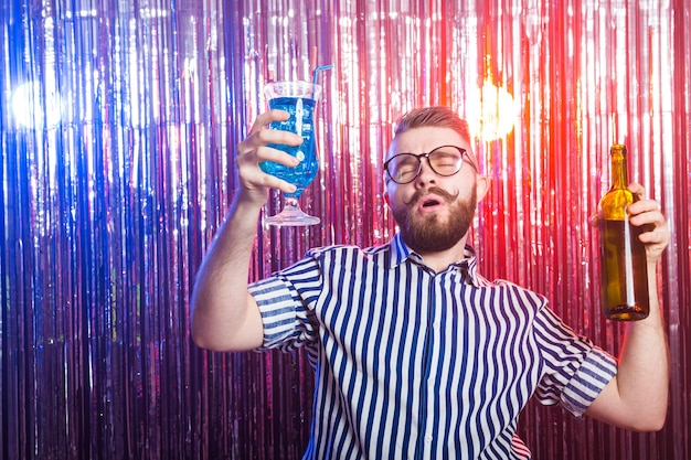 Koncepcja alkoholizmu, zabawy i głupca - pijany szalony facet na imprezie w nocnym klubie.