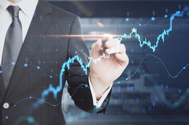 Koncepcja analizy inwestycji biznesowych i giełdy z biznesmenem w czarnym garniturze dotykająca wirtualnego interfejsu z diagramem i wykresami finansowymi
