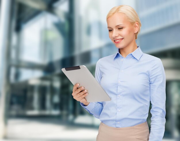 koncepcja biznesowa, internetowa i technologiczna - uśmiechnięta kobieta patrząca na komputer typu tablet pc