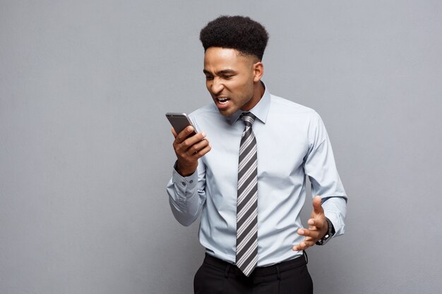 Koncepcja Biznesowa - Stresujący Biznesmen African American Krzyczy I Krzyczy Na Telefon Komórkowy.