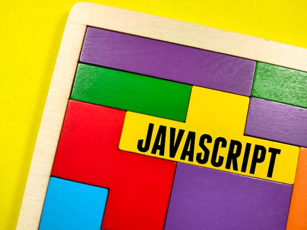 Koncepcja biznesowa Tekst JAVASCRIPT z drewnianą łamigłówką na żółtym tle