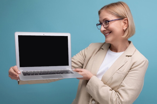 Koncepcja biznesowa w średnim wieku kobieta w kurtce z laptopem do pracy na tle studia z kopią