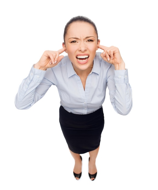 koncepcja biznesu i emocji - przerażona kobieta krzycząca z zamkniętymi uszami