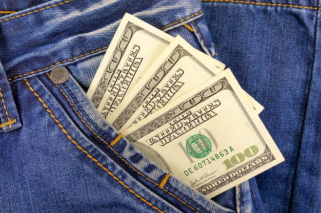 Koncepcja biznesu i finansów. Pieniądze dolary w kieszeni spodni jeansowych