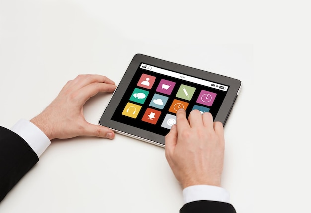 koncepcja biznesu, internetu, ludzi i technologii - zbliżenie rąk człowieka pracujących z ikonami aplikacji ekran komputera typu tablet pc