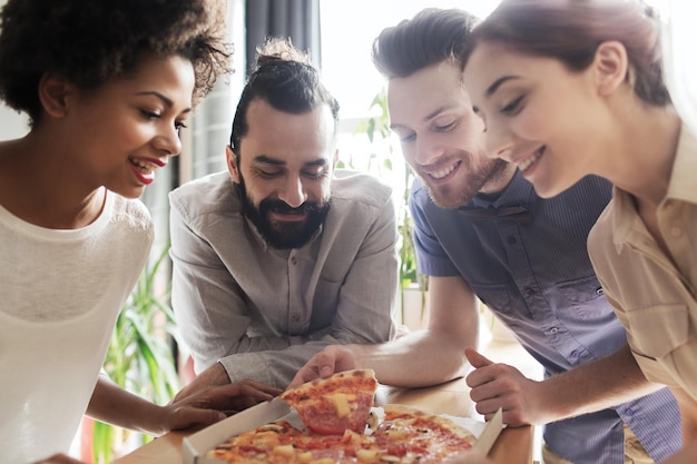 Koncepcja Biznesu, Jedzenia, Lunchu I Ludzi - Szczęśliwy Zespół Biznesowy Jedzący Pizzę W Biurze