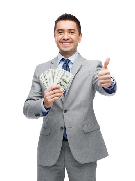koncepcja biznesu, ludzi i finansów - uśmiechnięty biznesmen z dolarowymi pieniędzmi pokazującymi kciuk w górę