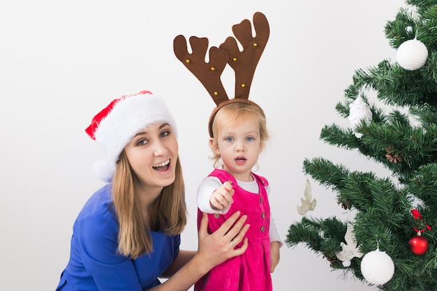 Koncepcja Bożego Narodzenia - matka i jej córeczka z choinką w salonie