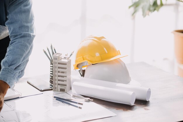 Koncepcja budowy i struktury spotkania inżyniera lub architekta w celu pracy nad projektem z partnerem i narzędziami inżynierskimi w zakresie budowy modelu i planu w umowie na miejscu pracy dla obu firm