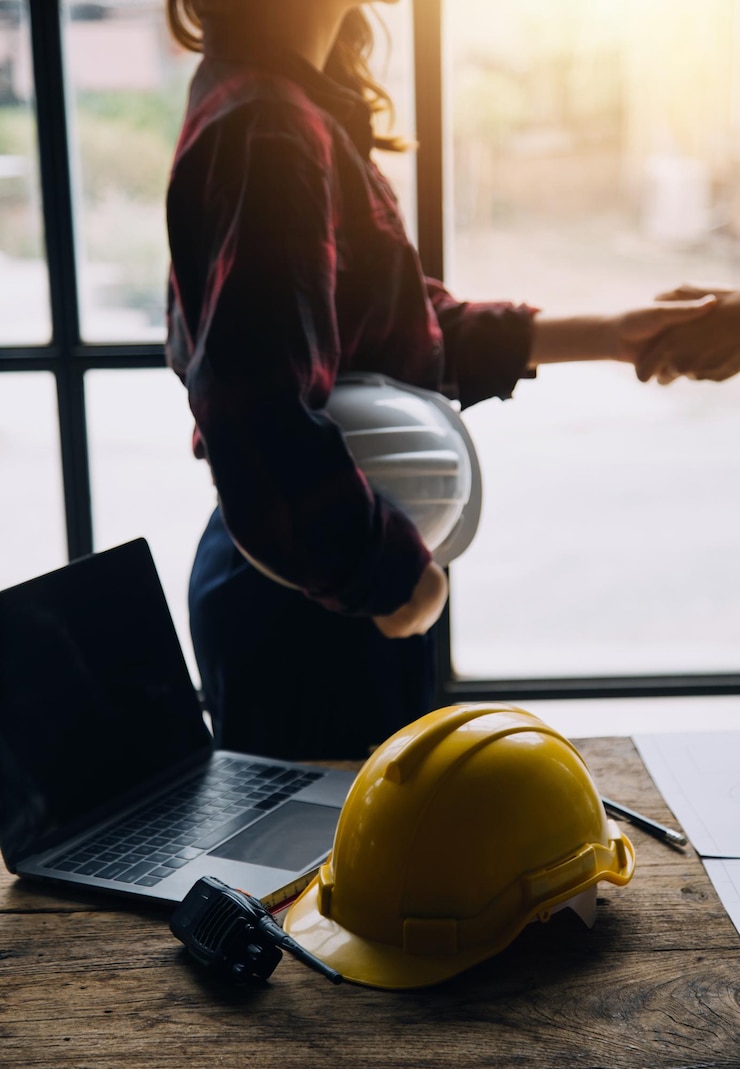 Zdjęcie koncepcja budowy inżyniera i architekta pracujących w budowie z niebieskim nadrukiem