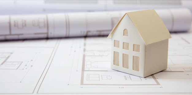 Zdjęcie koncepcja budowy rysunki budynków mieszkalnych i model domu architektonicznego na biurku