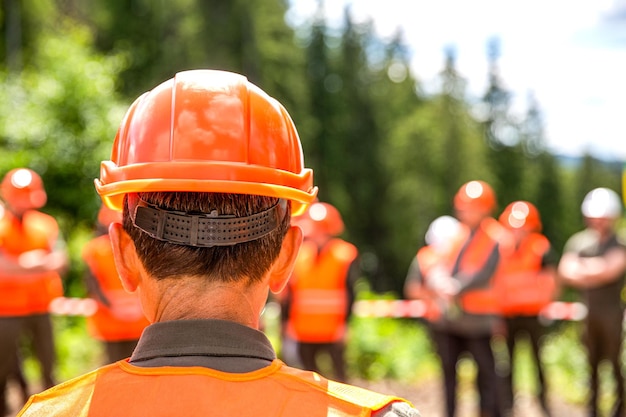 Koncepcja budynku Inżynierowie na budowie Konstruktor Konstruktor hełmów Wielu pracowników budowlanych w kaskach Zespół w kasku do pracy Grupa pracowników noszących kamizelkę ochronną