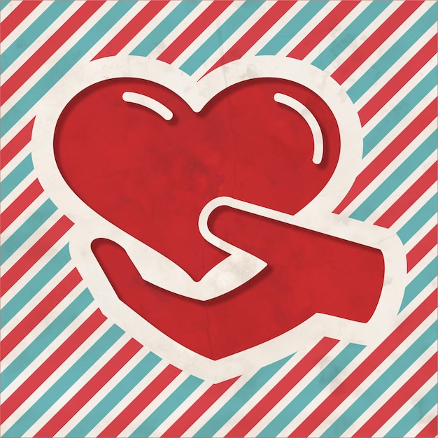 Koncepcja charytatywna - ikona serca w dłoni na tle czerwone i niebieskie paski. Vintage koncepcja w płaskiej konstrukcji.