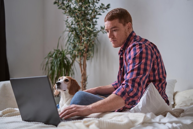Koncepcja cyfrowego stylu życia nomada mężczyzna jego laptop i jego zaufany Beagle sidekick odkrywający świat