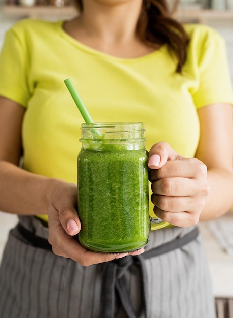 Koncepcja diety zdrowego odżywiania Zbliżenie młodej kobiety trzymającej słoik zielonego smoothie