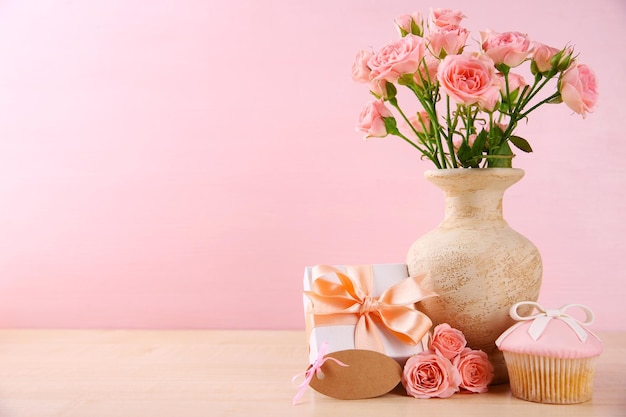 Koncepcja Dnia Matki Róże z babeczką na różowym tle