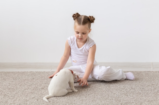 Koncepcja dzieci i zwierząt - szczeniak z właścicielem siedzi na podłodze.