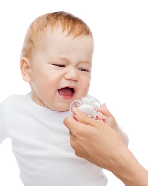 koncepcja dziecka i małego dziecka - płacz dziecka z smoczkiem