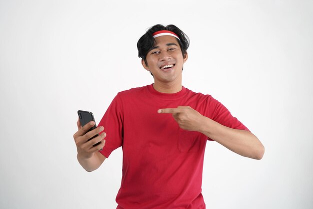 Koncepcja Dzień Niepodległości Indonezji. Indonezyjski mężczyzna patrzący na telefon komórkowy z wyrazem zaskoczenia