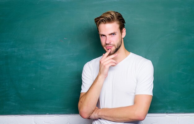 Koncepcja Edukacji. Człowiek Nauczyciel Na Lekcji W Szkole. Dzień Wiedzy. Powrót Do Szkoły. Pusta Tablica Informacyjna. Myślenie Studenta Przy Tablicy. Człowiek Gotowy Do Nauki. życie Studenckie.