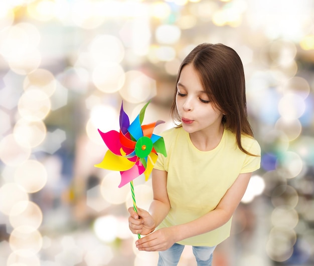 koncepcja edukacji, dzieciństwa i ekologii - uśmiechnięte dziecko z kolorową zabawką z wiatrakiem
