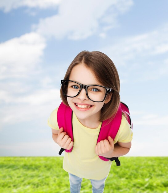 koncepcja edukacji i szkoły - szczęśliwa i uśmiechnięta nastolatka w okularach z torbą