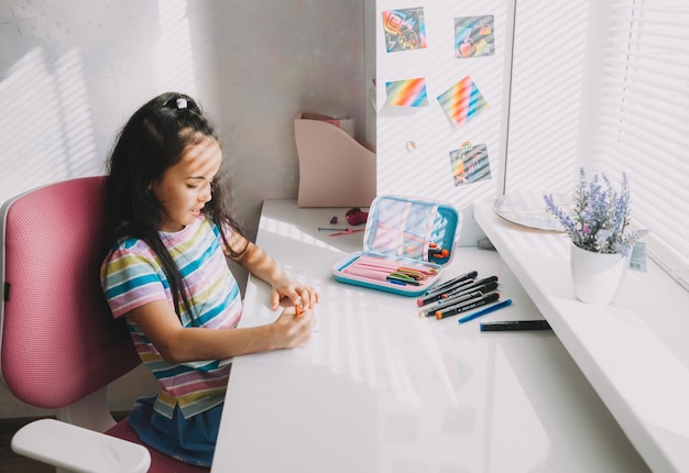 Koncepcja edukacji i uczenia się dzieci Uczennica pisząca przy biurku w domu