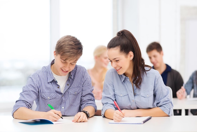 koncepcja edukacji, szkoły i ludzi - dwoje nastolatków z zeszytami w szkole